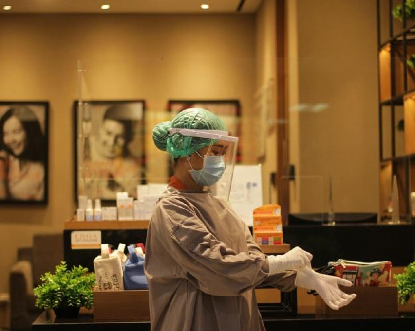 Female Doctor putting on surgical gloves wearing a full OR outfit